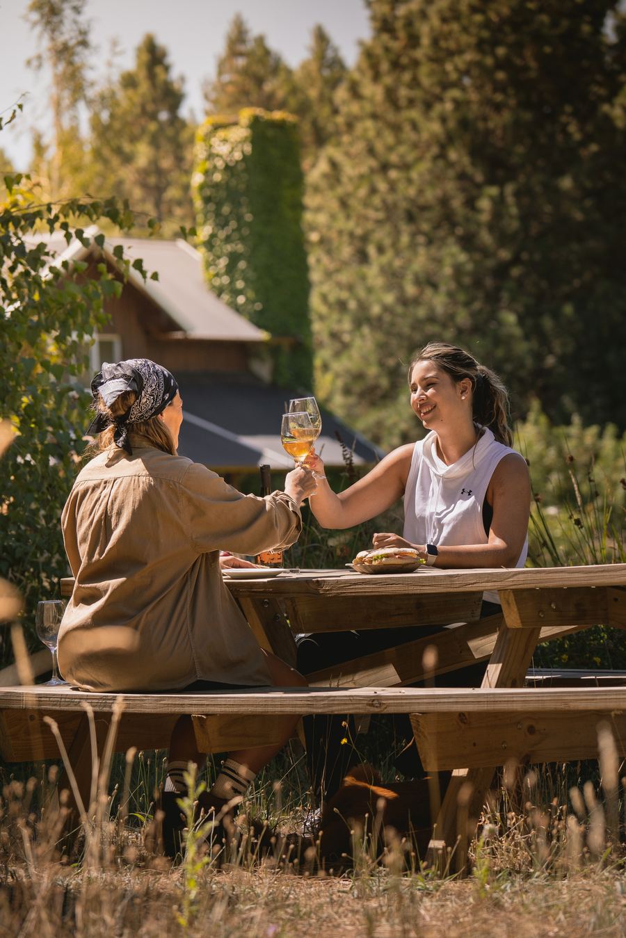 Dos amigas brindando en una mesa del jardín del refugio